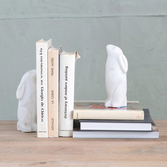Rabbit bookends displayed with a stack of books. 