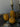 Three gourd shaped candles with white cotton wicks on a decorative surface.