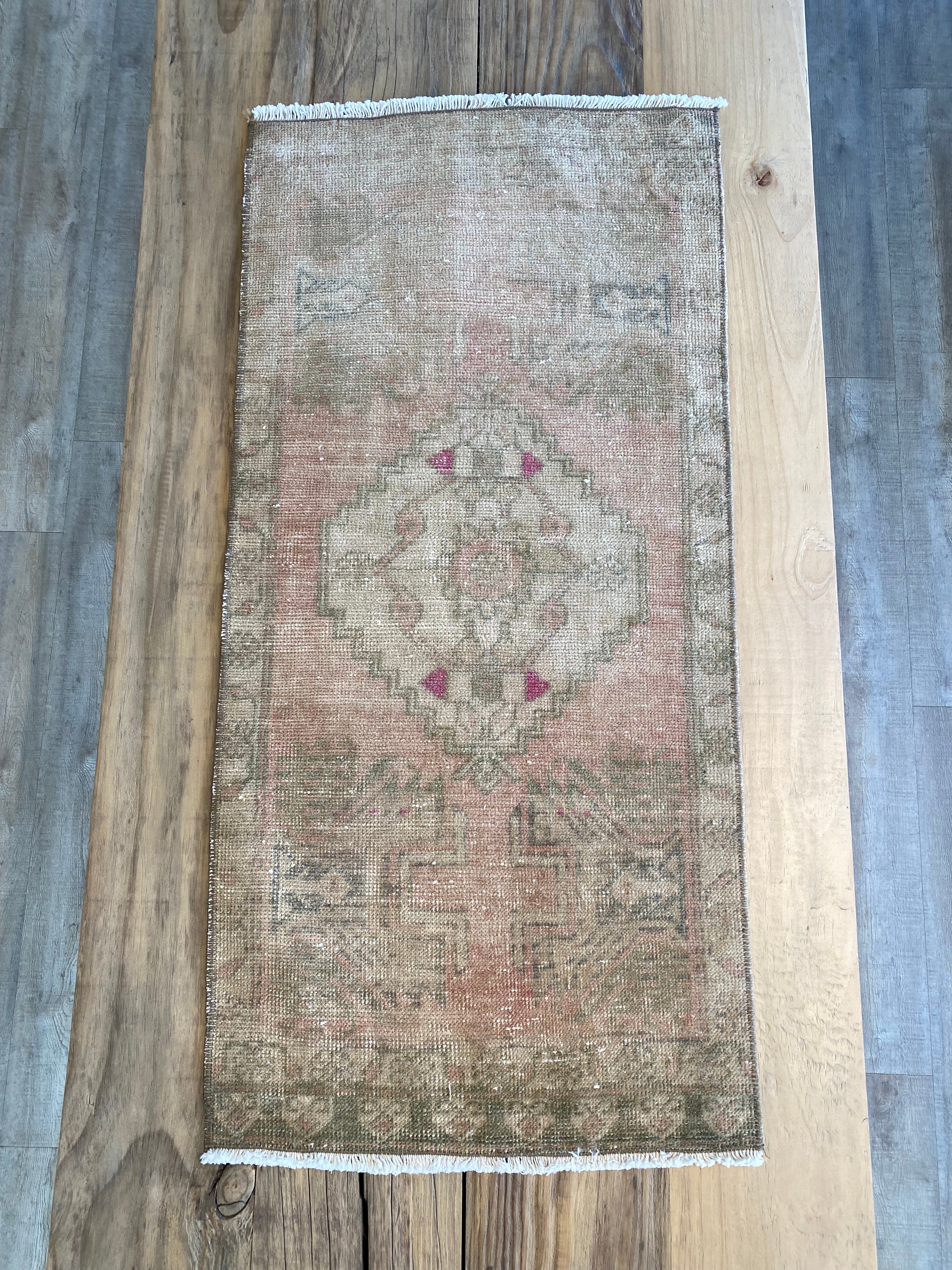 Authentic vintage Turkish rug in pale green, pale pink and beige with hints of hot pink.