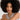 Woman with an afro wearing a gray sleeveless top against a light background.