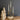 A set of three gold-finished forged iron taper holders designed to resemble deer antlers, displayed with lit candles on a wooden surface, with decorative wooden trees in the background.