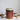 Spiced Cranberry scented soy wax candle in an amber glass jar with gold metal lid.