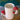 Close up of two of the Ceramic Mushroom Mugs, one stacked on the other next to a green fern.