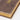 Close-up of a vintage journal with a worn brown cover and gilt-edged pages, showcasing its classic charm and textures.