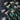 Artificial blush-colored chrysanthemums with dark centers and green stems laid out on a textured dark background in a flat lay arrangement.