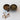 Rustic stoneware double dish with an organic handle, filled with pistachios and pumpkin seeds. The earthy brown glaze gives it a handcrafted, artisanal look. A few pistachios are scattered on the textured white surface.