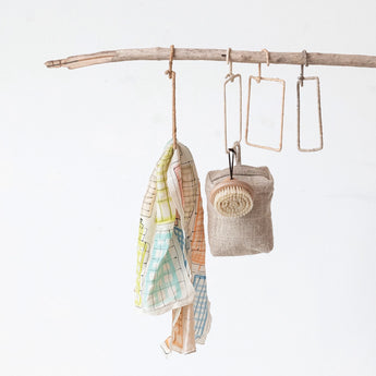 Small square hangers styled with a scarf, a bag and a scrub brush.
