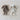 Knit fabric chenille bunny toy in two colors, one dark brown and one off-white, with long floppy ears and stitched facial features, laid on a neutral textured background.