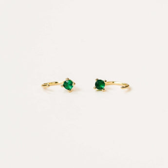 JaxKelly emerald colored huggies earrings.