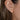 Model wearing delicate golden mushroom studs.