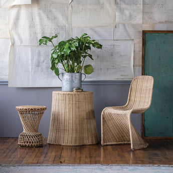 Rattan side table styled next to woven table and chair set.