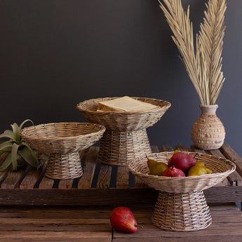 Three sizes of wicker compotes displayed with artificial fruit.