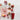 Decorative table setting with a red shaker, candy cane stir sticks, and Christmas ornaments on a light surface.
