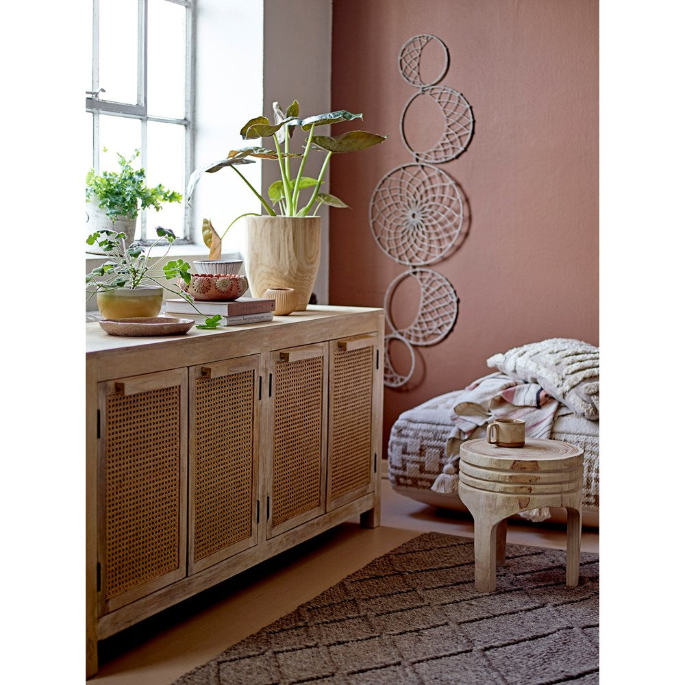 Solid Mango Wood Sideboard Buffet with Cane Rattan Doors Natural Finish in a room with plants, floor cushions and textured wall displays.