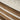 Close-up of wooden flooring with a textured beige carpet