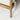 Close-up of a wooden chair leg with a textured fabric seat on a white background