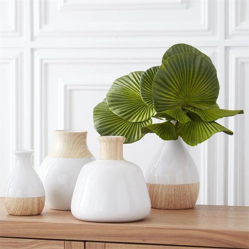 Fan palms grouped together in a white ceramic vase. 