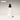 White face spritz bottle with black cap on a beige background