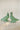 Two small decorative bird figurines with a distressed green patina finish, standing on a light stone surface against a soft off-white background.