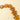 A close-up of amber-colored star-shaped beads strung on a cord, arranged diagonally on a light beige background.
