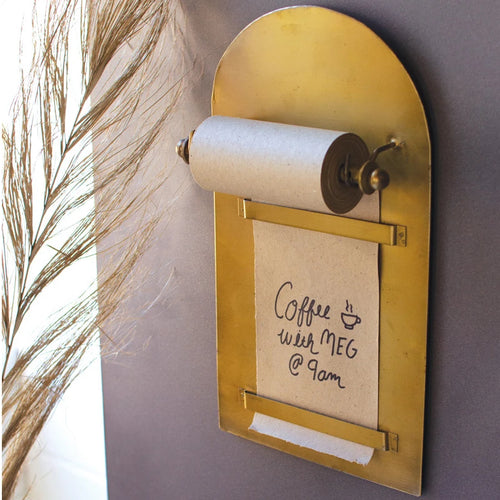 Magnetic Note Roll mounted on the side of a fridge with a handwritten note for a coffee date. 