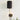 Plug-in antique gold wall lamp with fluted black metal shade on white wall.