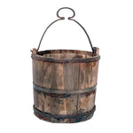 A vintage well bucket imported made of wood with an iron handle.