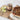 Jar of cherry almond spread on a wooden board with apples and a pie