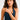 Woman wearing a navy blue halter top with a plain background