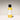 Yellow and white bottle of body wash with black cap on a gradient background