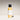 Body serum bottle with black cap and white label on a gradient background