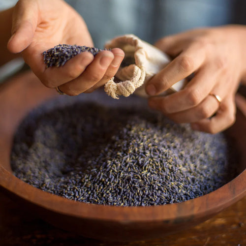 Bowl of lavender being placed into bags. 