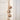Rustic String of Brass Finish Bells on a jute rope hanging from an antique door painted off white. 