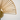 Close-up of wall-mounted brass fan sconce showing rattan wrapping and inline switch detail.