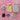 Set of toy clothing and a plush rabbit on a pink textured background