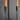 Close up of the black forged iron wall sconce with two taper candle holders with drippy beeswax taper candles in each holder.