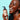 Woman holding a bottle of 'coconut vanilla' hand and body lotion against a light blue background.