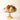 A pink and yellow glass compote filled with fresh fruit on a white background.