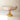 A pink and yellow coloured glass compote on a neutral coloured surface.