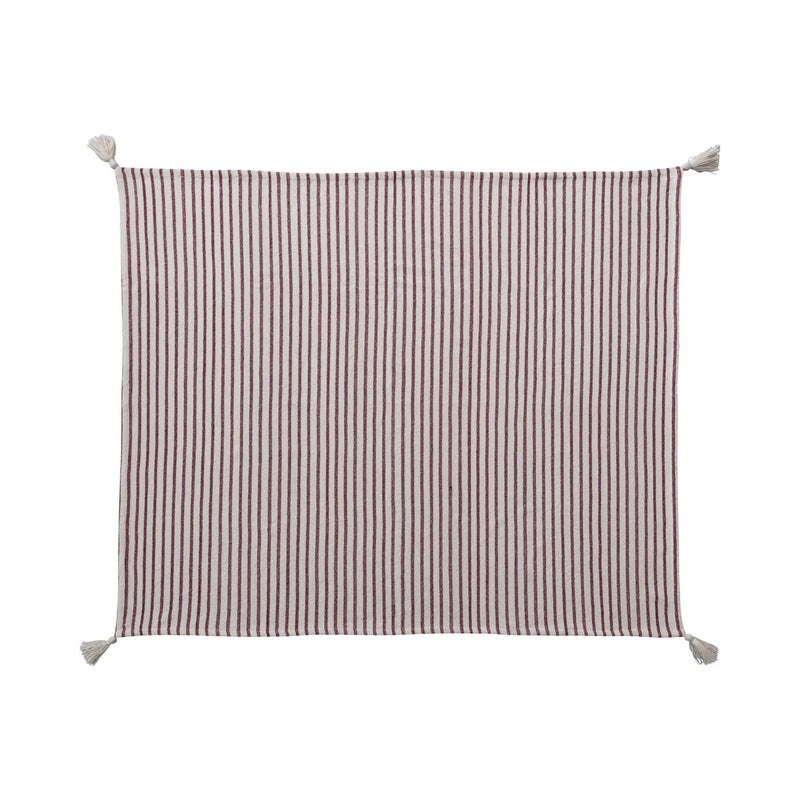 Cozy cream-colored cotton throw with tassels and red stripes. 