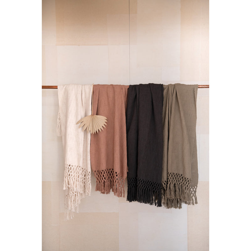 A row of Woven Cotton Throws with Crochet and Fringe in cream, pink, black and brown. 