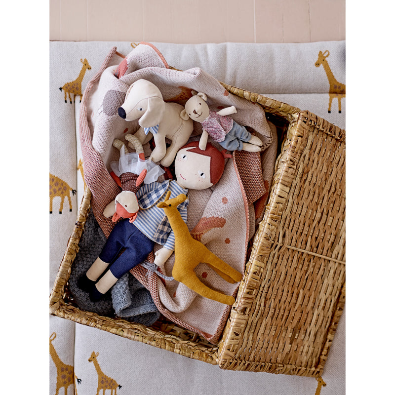 Plush toys in a basket with throw blankets. 