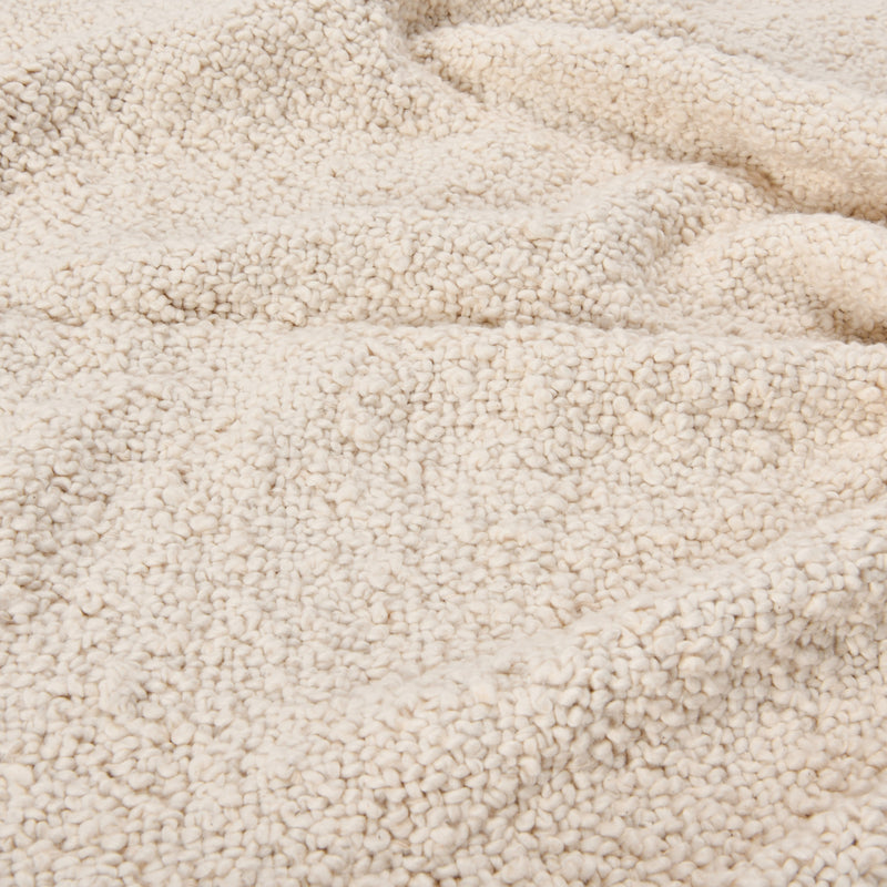Textured, soft and cozy material of the cotton boucle throw up close. 