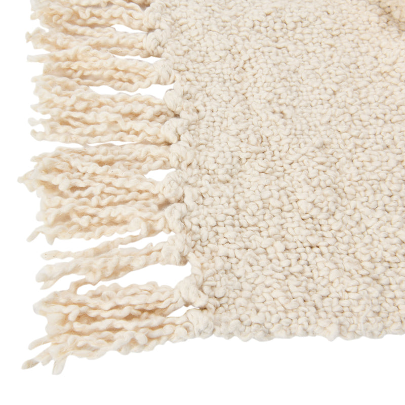 Up close view of the fringe detail on the woven boucle throw.