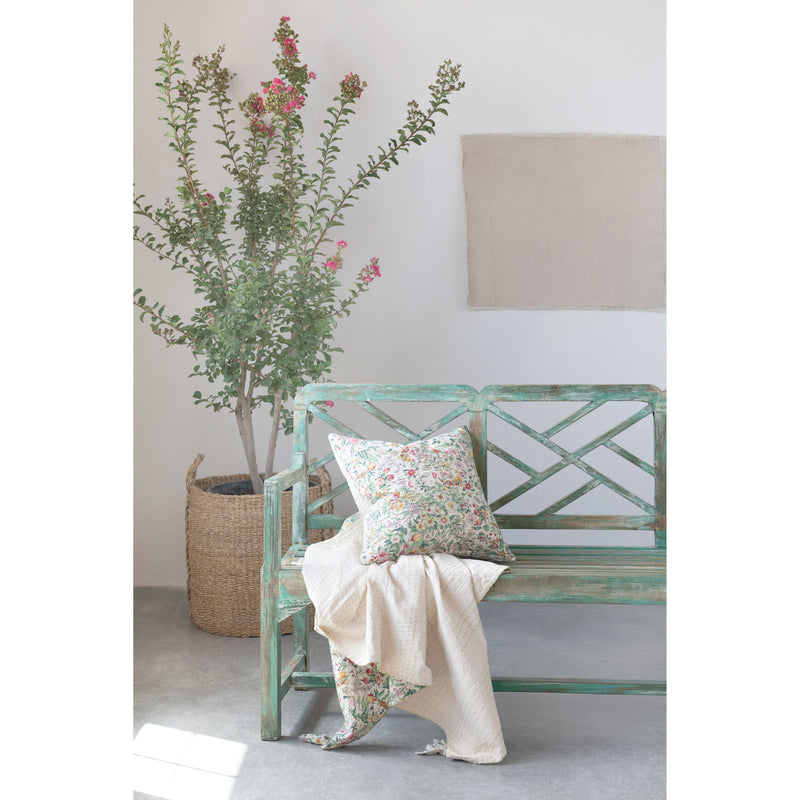 Quilted Cotton Throw with Floral Pattern and matching cushion on a distressed green wood bench. 