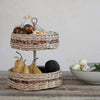 Woven wicker tiered tray in kitchen for fruit storage on countertop. 