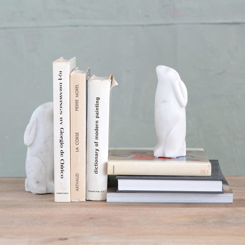 Rabbit bookends displayed with a stack of books. 