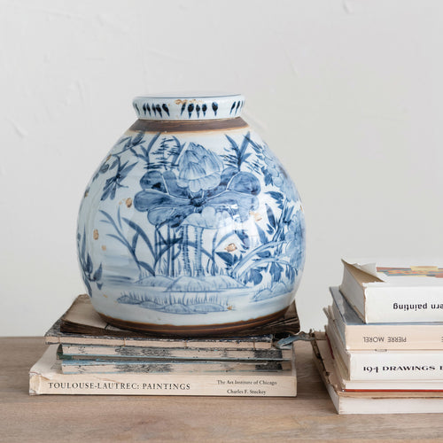 Decorative Stoneware Ginger Jar styled on top a stack of antique books. 