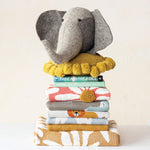 A stack of little one decor including the cozy Cotton Knit Throw with Flowers & Embroidery.