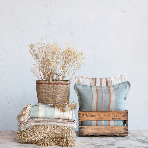 Woven Cotton & Linen Throw with Stripe and matching pillows displayed in antique crates with dried florals. 